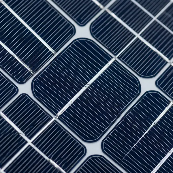 Detailed close-up of a monocrystalline solar panel surface showing silicon cells.